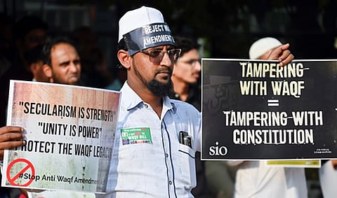 A man holding placards protests demanding the repeal of Waqf Amendment Act 2025, at Freedom Park in Bengaluru on April 7.