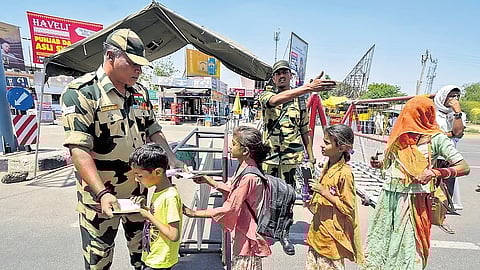 A BSF personnel checks documents of Pakistani nationals arriving to cross over to their country as the deadline to exit India nears its end