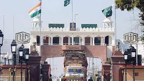 Indian Border Security Force (BSF) personnel (L) and Pakistani Rangers (R) allow a Pakistani truck to cross over to India at the Wagah Border