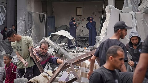 Palestinians search the rubble of a house targeted by an Israeli army strike that killed killing at least five members of the Abu Sahloul family in Khan Younis, in the southern Gaza Strip, Thursday, May 1, 2025
