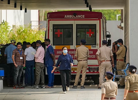 Medics and police personnel outside the mortuary of a hospital, where victims of the Air India plane crash were admitted, in Ahmedabad, Sunday