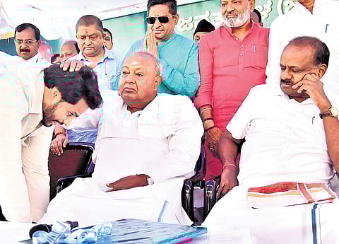 JDS Youth Wing president Nikhil Kumaraswamy seeks blessings of his grandfather and party supremo HD Deve Gowda, as his father and Union Minister HD Kumaraswamy looks on