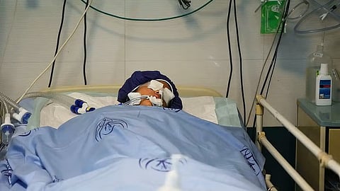 A Boy  unconscious in a hospital bed 