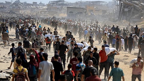 Palestinians gather as they carry aid supplies
