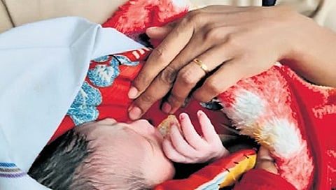 An RPF personnel keeps the newborn warm at Sir M Visvesvaraya Terminal 