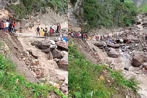 People move across an affected area after a flash flood following a cloudburst in Chashoti area of Kishtwar, Thursday.