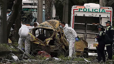 Security forces inspect the site of a bomb explosion outside an Air Force base in Cali, Colombia, Thursday, Aug. 21, 2025. 