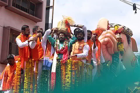 'Balapur Ganesh Laddu' on his head after winning the open auction with a successful bid of Rs 35 lakhs at Balapur on Saturday. 