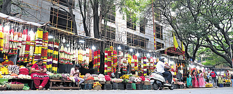 Vendors sell flowers in temporary stalls in front of the upcoming BDA complex on Sampige Road in Malleswaram.Photo | Kevin Nashon / Express