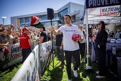 Charlie Kirk hands out hats before speaking at Utah Valley University in Orem, Utah