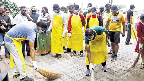 Central City Commissioner Rajendra Cholan and other GBA staff clean a footpath in Majestic