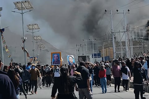 In this photo from Sept. 24, 2025, smoke rises from buildings including the local office of the BJP set ablaze during protests in Leh town, Ladakh on Wednesday