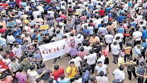 Protesters hold up a large banner with “Gen-Z” printed on it, in Dharwad on Friday.