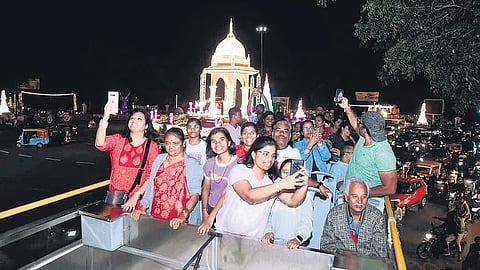 People enjoy their ride and click pictures on the upper deck of the Ambaari service in Mysuru on Sunday.