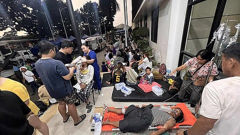 Patients wait outside the Cebu Provincial Hospital Bogo City after a strong earthquake struck in Bogo city, Cebu province, central Philippines
