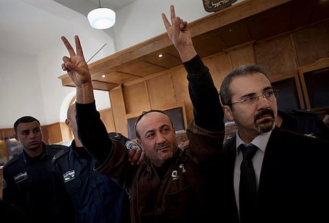 Senior Fatah leader Marwan Barghouti makes the victory sign in front of the media during his arrival to testify in a trial at a Jerusalem court