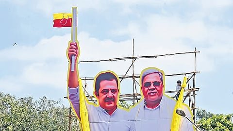 A worker fixes a cutout of CM Siddaramaiah and minister BZ Zameer Ahmed Khan