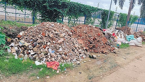 Heaps of construction waste lie along the canal road in White Field 