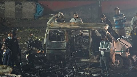 Officers from various security agencies investigate the spot after a blast occurred in a parked car near Red Fort, leaving multiple vehicles in flames, in New Delhi