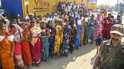 Voters wait in a queue to cast votes at a polling station during the first phase of the Bihar Assembly elections, at Danapur in Patna