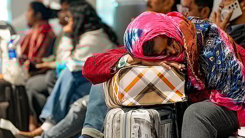 A passenger rests while waiting at Terminal 1 (T1) of the Indira Gandhi International Airport, in New Delhi, Saturday, Dec. 6, 2025.