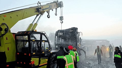 Cranes clear the charred remains of buses after a fog-hit pile-up involving several buses and cars triggered fires on the Yamuna Expressway.