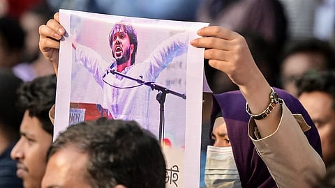 An activist holds a poster of Sharif Osman Hadi,