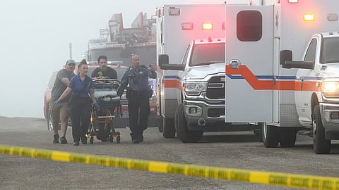 Emergency personnel rush a victim of a small plane crash