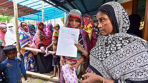 People check their names on the final draft of the state's National Register of Citizens