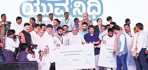 CM Siddaramaiah hands over stipend cheques to beneficiaries of the Yuva Nidhi scheme in Shivamogga
