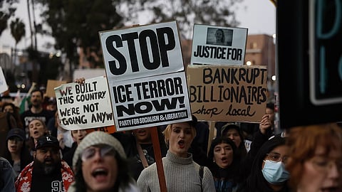 Demonstrators hold signs during a protest in response to the fatal shooting of 37-year-old Alex Pretti in Minneapolis earlier in the day Saturday.