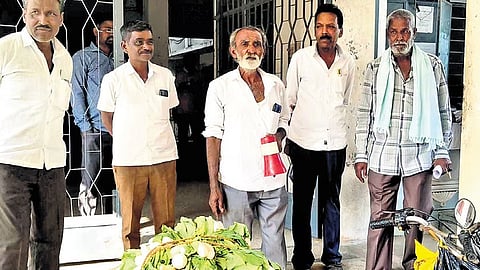 Prasanna Kumar (centre) stages a protest in front of the taluk office at Madhugiri in Tumakuru district on Tuesday.
