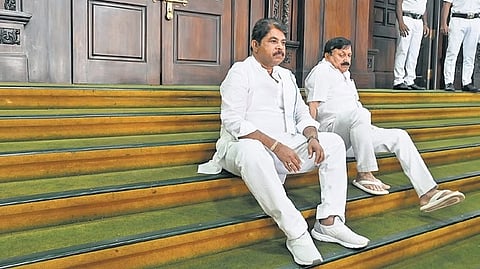 R Ashoka and former home minister Araga Jnanendra sit on the steps leading to the Assembly after the Opposition’s overnight dharna seeking the resignation 