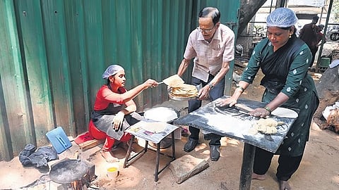 A cook at a hotel in Karnataka Chitrakala Parishath prepares food with firewood on Sunday after LPG cylinder supply petered out across the city on Sunday.