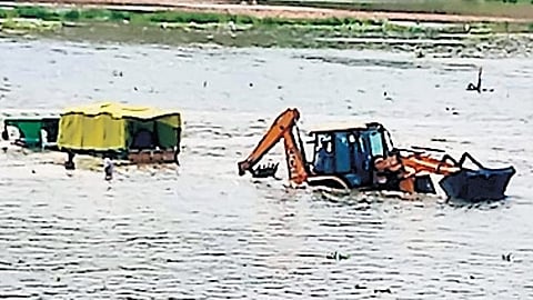 A videograb of the tractor being pulled out using a crane 