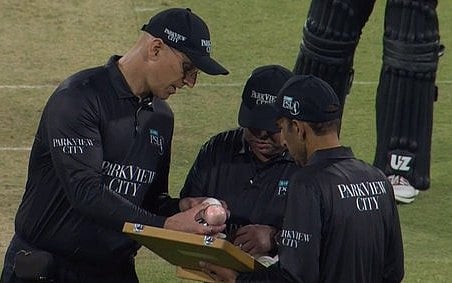 Pakistan Super League umpire inspect the 'pink' ball.