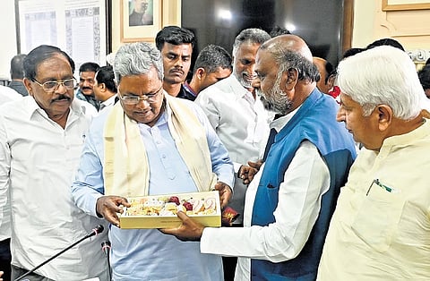 Former minister H Anjaneya distributes sweets to CM Siddaramaiah and ministers after the cabinet decided to implement 15% internal quota for Scheduled Castes