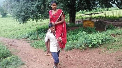ಗರ್ಭಿಣಿ ಪತ್ನಿಯನ್ನು ಹೊತ್ತು ನಡೆಯುತ್ತಿರುವ ಪತಿ
