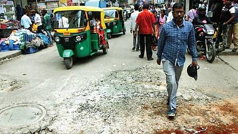 ಮಣ್ಣು, ಕಲ್ಲುಗಳಿಂದ ಅವೆನ್ಯೂ ರಸ್ತೆಯ ಗುಂಡಿಗಳನ್ನು ಮುಚ್ಚುತ್ತಿರುವುದು