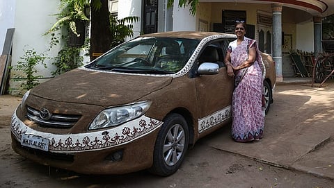 ಕಾರಿಗೆ ಸಗಣಿ ಸಾರಿಸಿರುವ ಮಹಿಳೆ