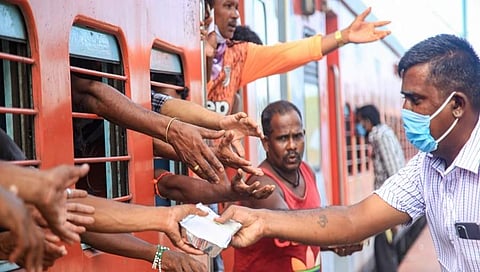 ರೈಲಿನಲ್ಲಿ ತಮ್ಮೂರಿಗೆ ಪ್ರಯಾಣಿಸುತ್ತಿರುವ ವಲಸೆ ಕಾರ್ಮಿಕರಿಗೆ ಉಚಿತ ಆಹಾರ ಧಾನ್ಯ ವಿತರಿಸುತ್ತಿರುವುದು