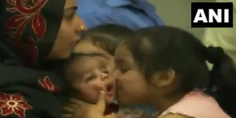 ಶಿಶುವಿಗೆ ಮುತ್ತಿಕ್ಕುತ್ತಿರುವ ಬಾಲಕಿ