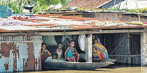 ಪ್ರವಾಹ ಹಿನ್ನೆಲೆಯಲ್ಲಿ ದೋಣಿಯಲ್ಲಿ ಕುಳಿತಿರುವ ಜನರು