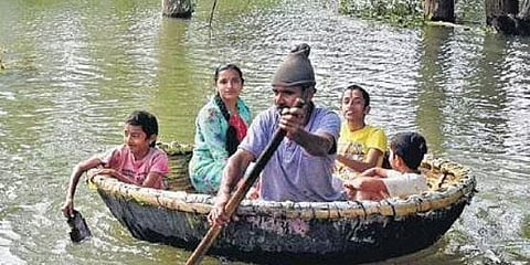 ತೆಪ್ಪದಲ್ಲಿ ಹುಟ್ಟುಹಾಕುತ್ತಿರುವ ಪಾಷಾ