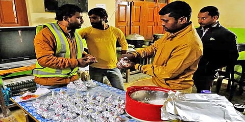 ಸಿಕ್ಕಿಹಾಕಿಕೊಂಡಿರುವ ಕಾರ್ಮಿಕರಿಗೆ ಕಳುಹಿಸಲು ಆಹಾರ ಪೊಟ್ಟಣ ಸಿದ್ಧಮಾಡುತ್ತಿರುವುದು