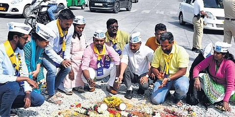 ಗುಂಡಿಬಿದ್ದ ರಸ್ತೆಗೆ ಪೂಜೆ ಮಾಡುತ್ತಿರುವ ಆಪ್ ಸದಸ್ಯರು.