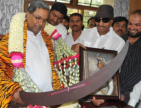ಟಿಪ್ಪು ಸುಲ್ತಾನ ಭವನ ನಿರ್ಮಿಸುವಂತೆ ಕೋರಿ ಮಾಜಿ ಶಾಸಕ ವಾಟಾಳ್ ನಾಗರಾಜ್ ಅವರು ಗೃಹ ಕಚೇರಿ ಕೃಷ್ಣಾದಲ್ಲಿ ಮುಖ್ಯಮಂತ್ರಿ ಸಿದ್ದರಾಮಯ್ಯ ಅವರಿಗೆ ಮರದ ಖಡ್ಗ ನೀಡಿ ಗೌರವಿಸಿದರು.