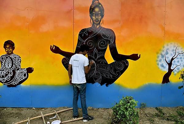 <b>ಯೋಗ ದಿನಕ್ಕೆ ಸಿದ್ಧತೆ...</b>. ಅಂತರಾಷ್ಟ್ರೀಯ ಯೋಗ ದಿನದ ಅಂಗವಾಗಿ ಯೋಗದ ಬಗ್ಗೆ ಜನತೆಯಲ್ಲಿ ಅರಿವು ಮೂಡಿಸುವುದಕ್ಕಾಗಿ ಕಲಾವಿದರೊಬ್ಬರು ಶನಿವಾರ ದೆಹಲಿಯಲ್ಲಿ ರಸ್ತೆ ಬದಿಯ ಗೋಡೆ ಮೇಲೆ ಯೋಗಾಸನದ ಚಿತ್ರ ಬಿಡಿಸುತ್ತಿರುವುದು.