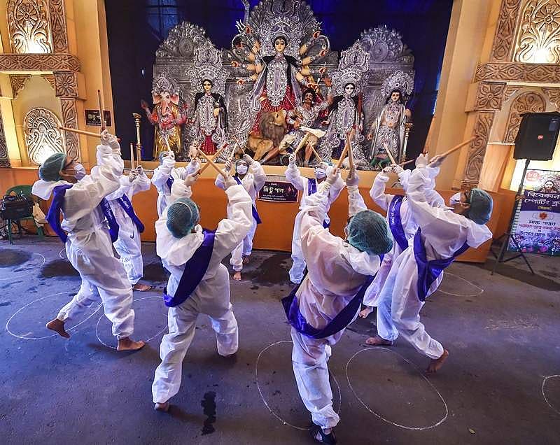ಕೋಲ್ಕತಾದ ದುರ್ಗಾ ಪೂಜೆ ಪೆಂಡಾಲ್ ನಲ್ಲಿ ಪಿಪಿಇ ಕಿಟ್ ಧರಿಸಿ ಪ್ರದರ್ಶನ ನೀಡುತ್ತಿರುವ ಕಲಾವಿದರು