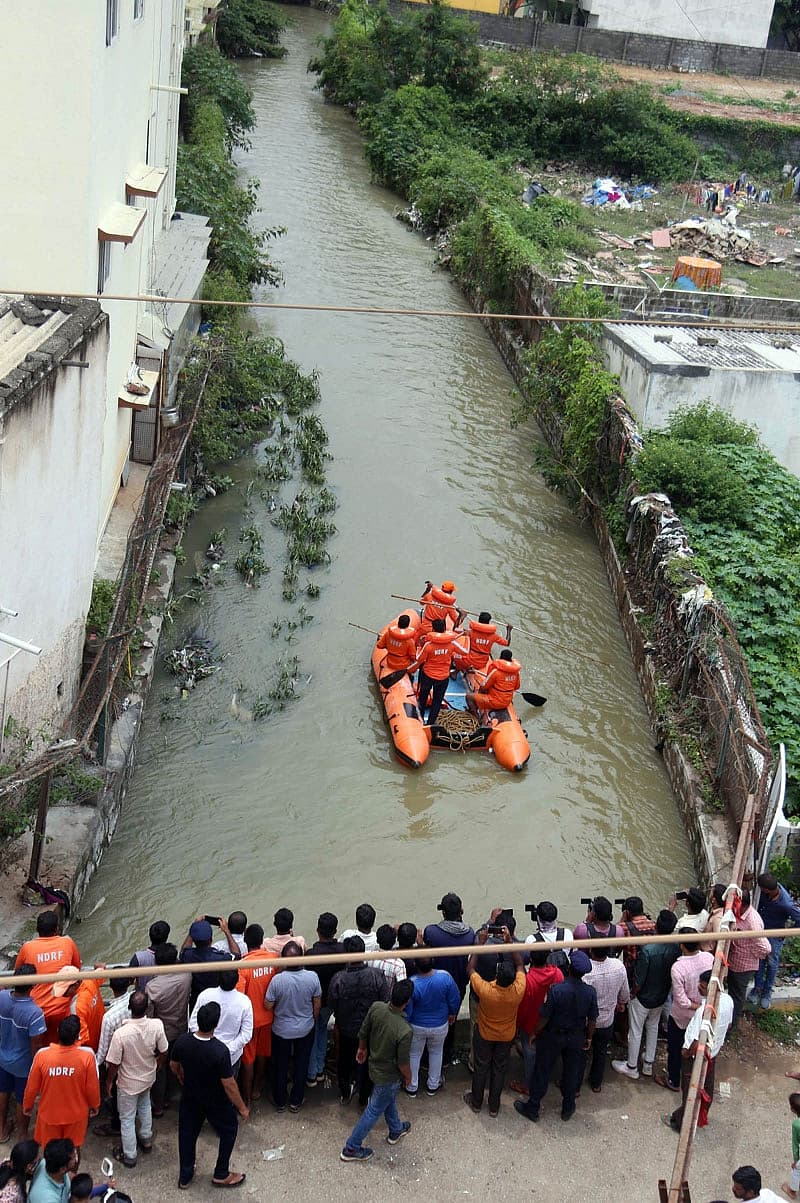 ರಾತ್ರಿ ಸುರಿದ ಮಳೆಗೆ ಚರಂಡಿಗೆ ಹೊಂದಿಕೊಂಡಿರುವ ಕಾಂಪೌಂಡ್ ಗೋಡೆ ಕುಸಿದು ಮನೆ ಬಳಿ ನಿಲ್ಲಿಸಿದ್ದ ಬೈಕ್‌ಗಳ ಮೇಲೆ ಬಿದ್ದಿದೆ.  ಈ ವೇಳೆ ಚರಂಡಿ ನೀರಿನಲ್ಲಿ ಕೊಚ್ಚಿಹೋಗುತ್ತಿದ್ದ ಬೈಕ್ ನ್ನು ಮೂವರು ಎಳೆಯಲು ಯತ್ನಿಸಿದ್ದಾರೆ.
